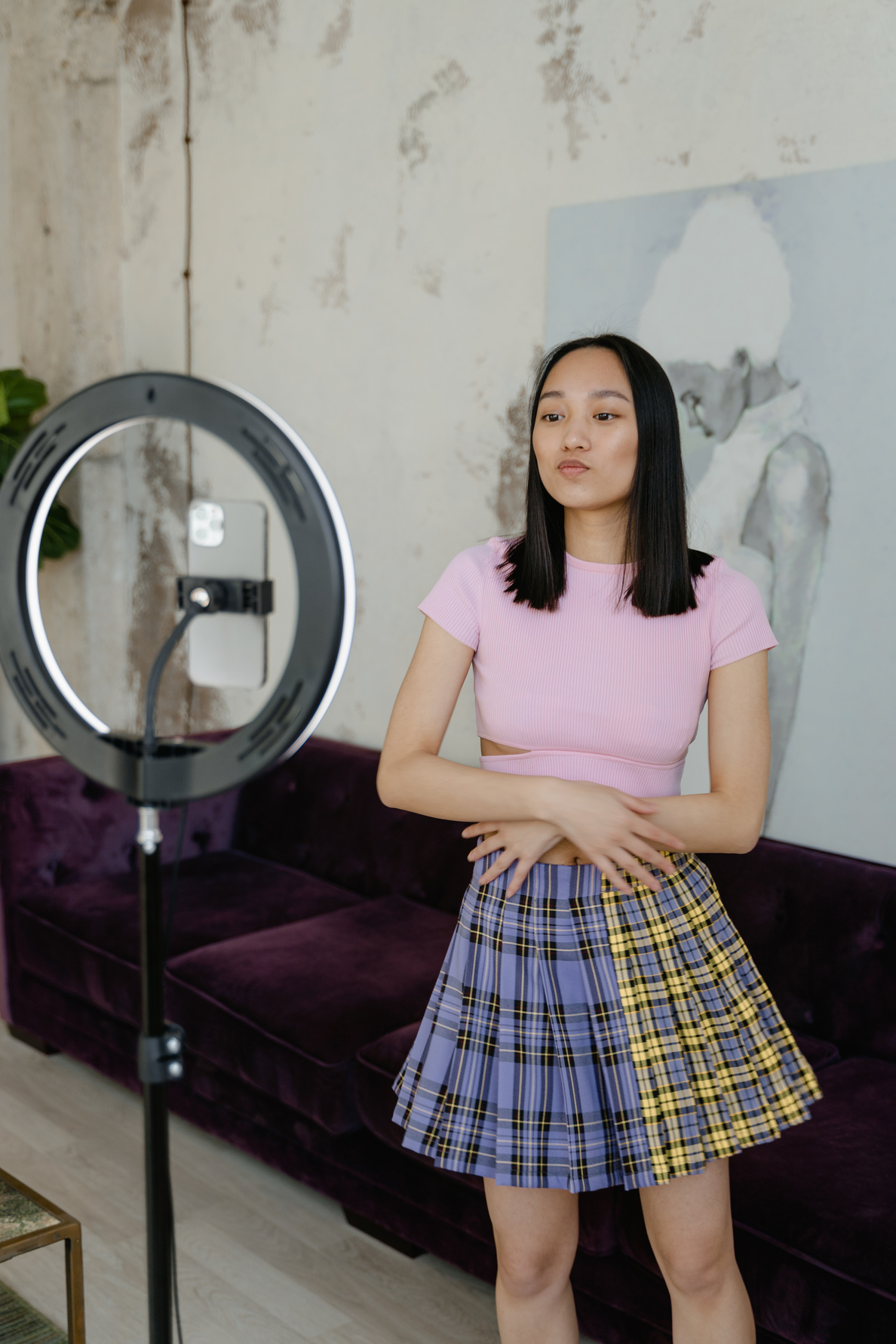 Woman in Pink Shirt and Blue Skirt Standing Beside Round Mirror